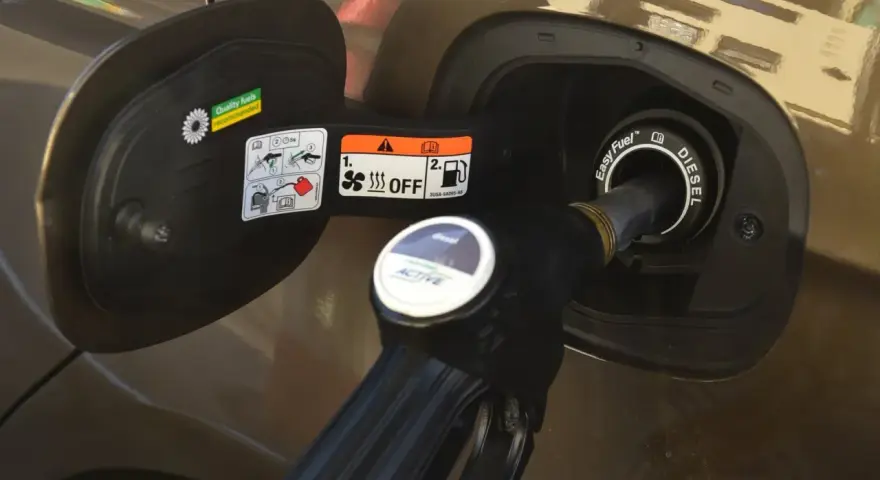 Dozbrań do baku diesla. Pistolet paliwowy wlewa paliwo do samochodu, pokazując, jak zatankować auto.
