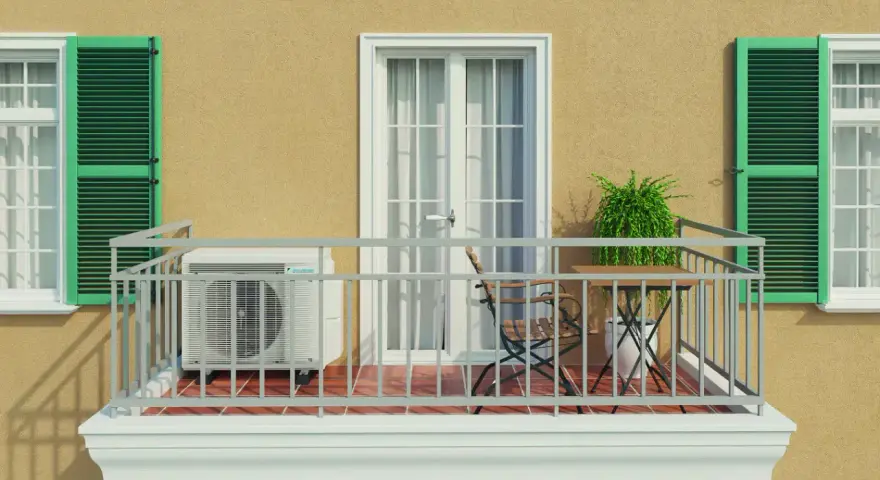 Balkon eines Mehrfamilienhauses mit Klimaanlage, Tisch und Stuhl. Grüne Fensterläden und eine Tür mit Vorhängen.