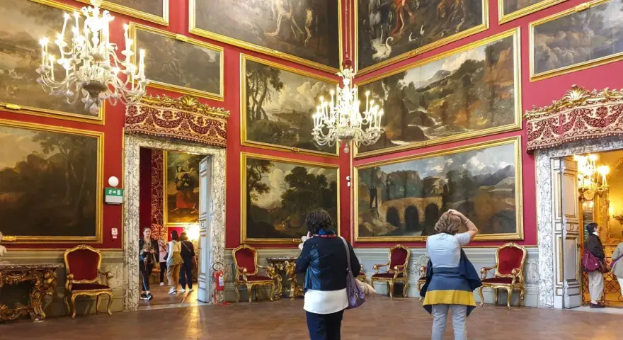 Wnętrze Galerii Doria Pamphilj z obrazami i żyrandolami.