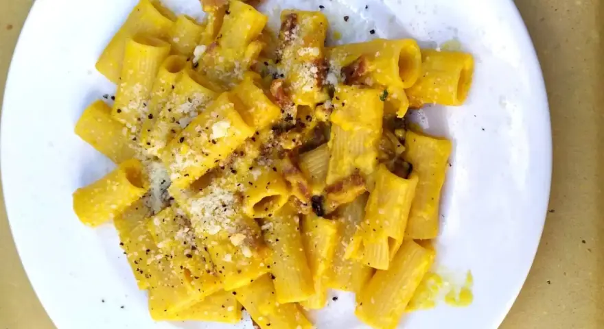 Macarrones con nata, cubiertos de queso rallado y pimienta negra, con trocitos de bacon crujiente.