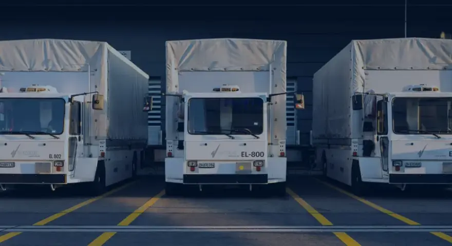 Drei weiße LKWs stehen nebeneinander vor einem Gebäude. Ein LKW-Fahrverbot am Wochenende könnte hier gelten.