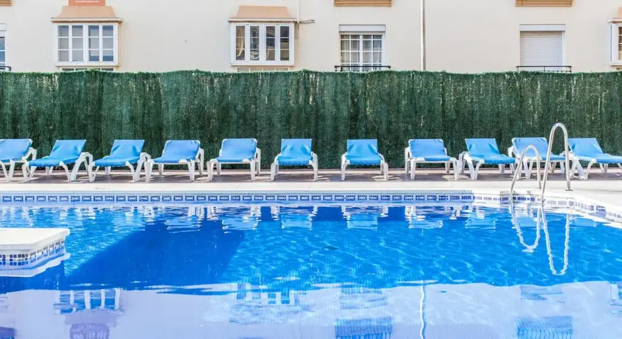 Błękitne morze przy hotelu Gran Cervantes, puste leżaki czekają na gości.