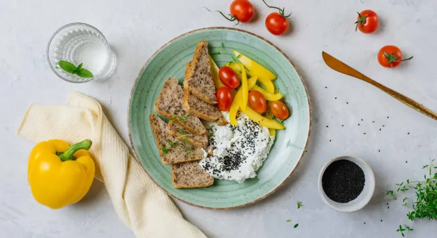 Talerz z twarogiem, pieczywem, pomidorkami i papryką. Idealne na śniadanie z serii dieta wysokobiałkowa przepisy.