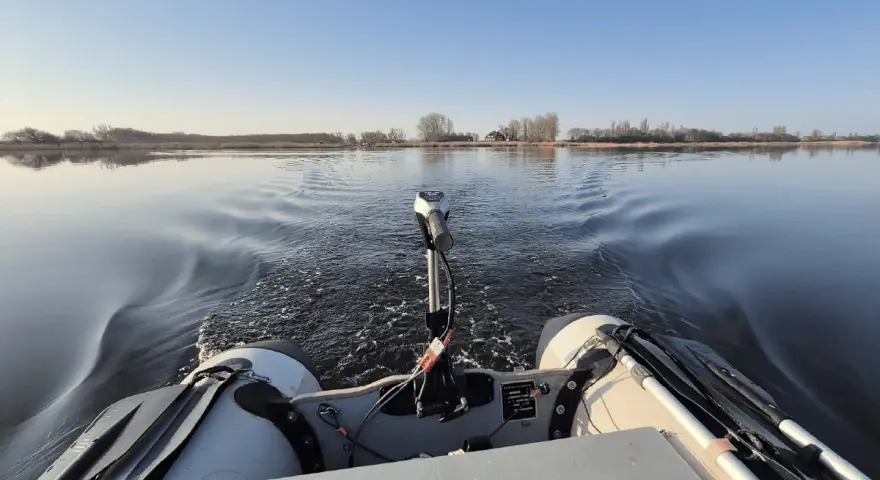 Schlauchboot mit Außenborder auf ruhigem Wasser. Die Beleuchtung des Schlauchboots entspricht der Vorschrift für sicheres Fahren.