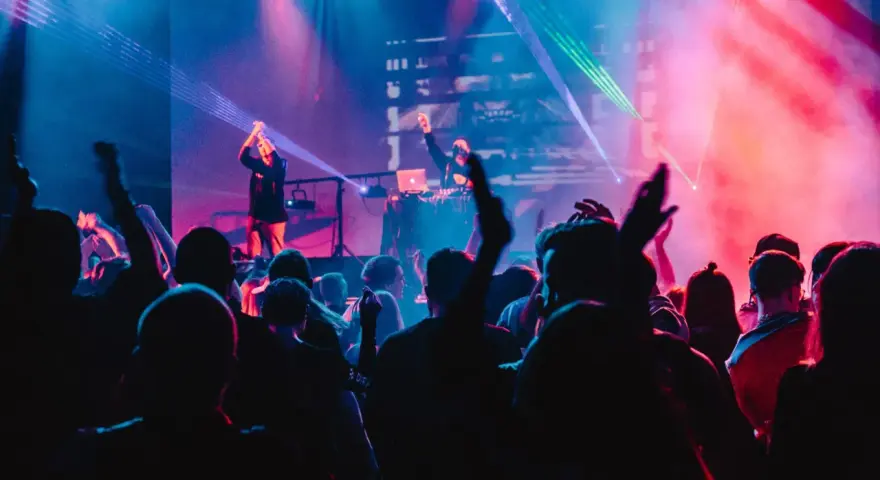 Eine Menge feiert zu A&R Music bei einem Konzert mit Lasershow.