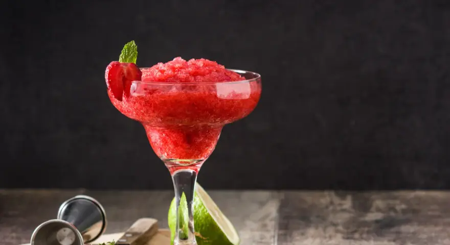 En fryst strawberry daiquiri med mynta och jordgubbsdekoration, redo att avnjutas.