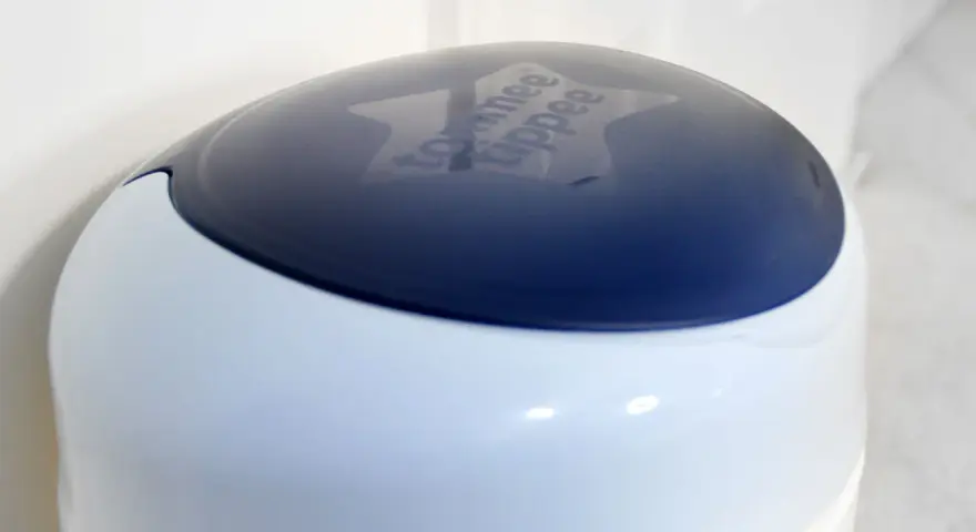 Niebieska pokrywa kosza na pampersy Tommee Tippee z wygrawerowanym logo.