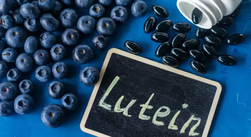 Jagody i kapsułki z luteiną na oczy. Na tabliczce napis "Lutein".