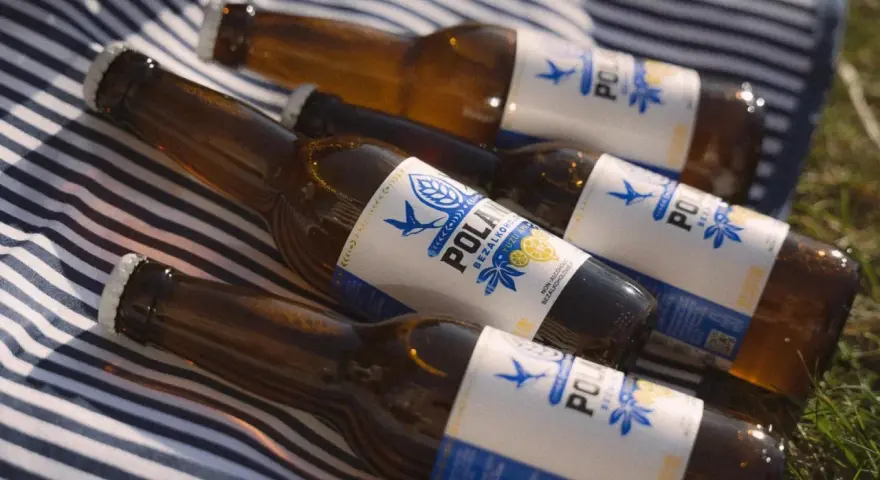 Idealne piwo po bieganiu: cztery butelki bezalkoholowego napoju na kocu w paski.