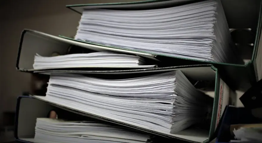 Stosy dokumentów w segregatorach, gotowe do złożenia jako list motywacyjny do urzędu.