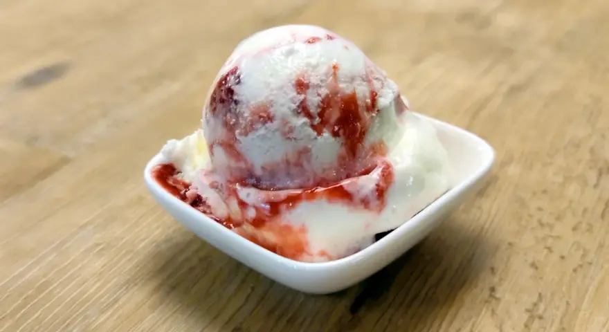 Ein Eisbecher mit Erdbeersoße, der zum sofortigen Genuss einlädt. Ein wahrer "Ed von Schleck" Moment!
