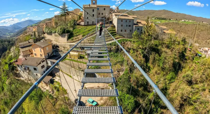 Ponte tibetano sellano, una passerella sospesa che collega borghi antichi, offre una vista mozzafiato sulla valle. La sua lunghezza è un'avventura.