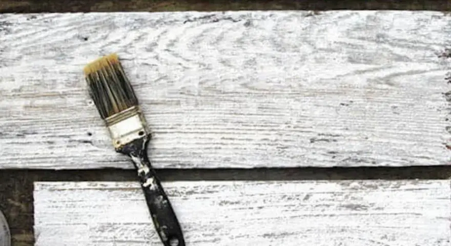Pennello sporco su assi di legno bianco, pronto per la cementite per legno già verniciato.