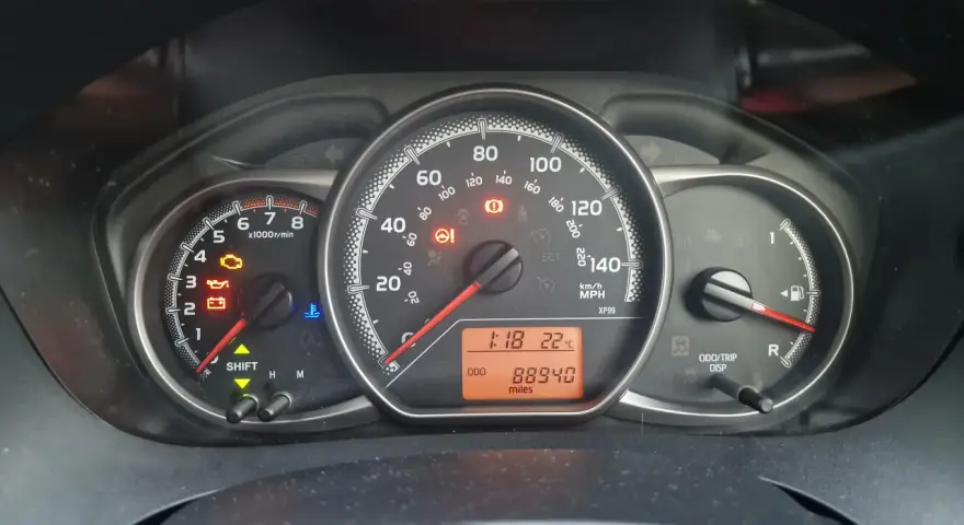 Kontrolka silnika świeci się na desce rozdzielczej Toyoty, wskazując błąd DTC P1604. Oprócz tego widoczne są kontrolki oleju, akumulatora i temperatury.
