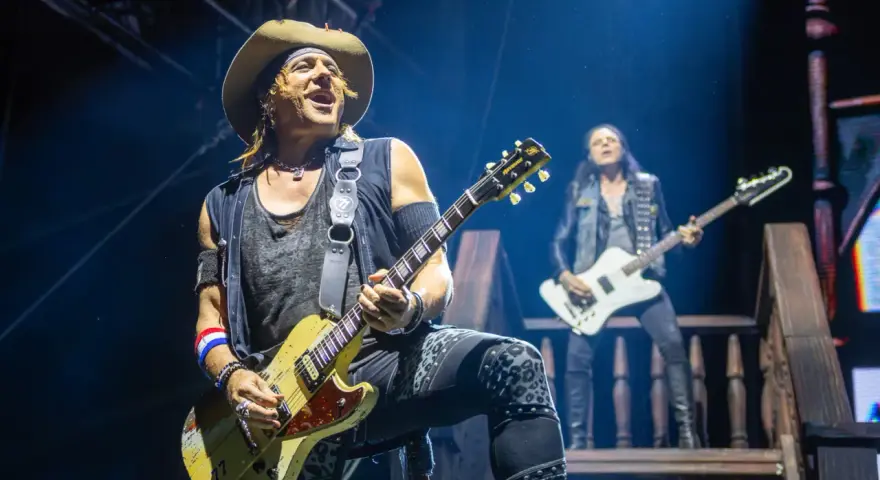Ein Gitarrist mit Hut spielt auf der Bühne, im Hintergrund ein weiterer Musiker. Ein Konzert von Alice Cooper.