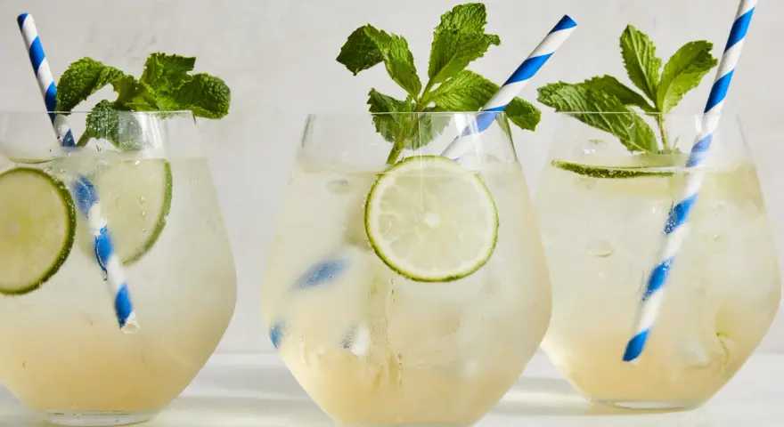 Tre svalkande Hugo Spritz med mynta och lime, perfekta för en solig dag.