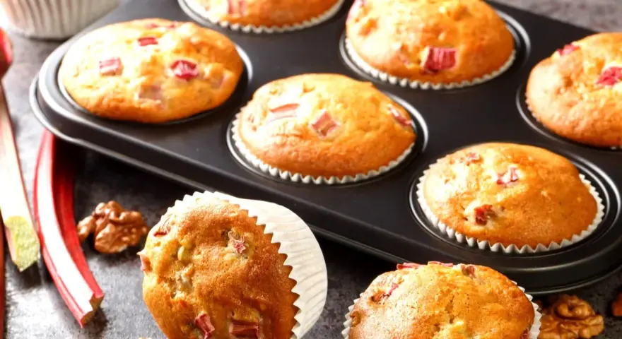 Pyszne muffinki z rabarbarem, świeżo upieczone, z kawałkami rabarbaru i orzechami włoskimi.