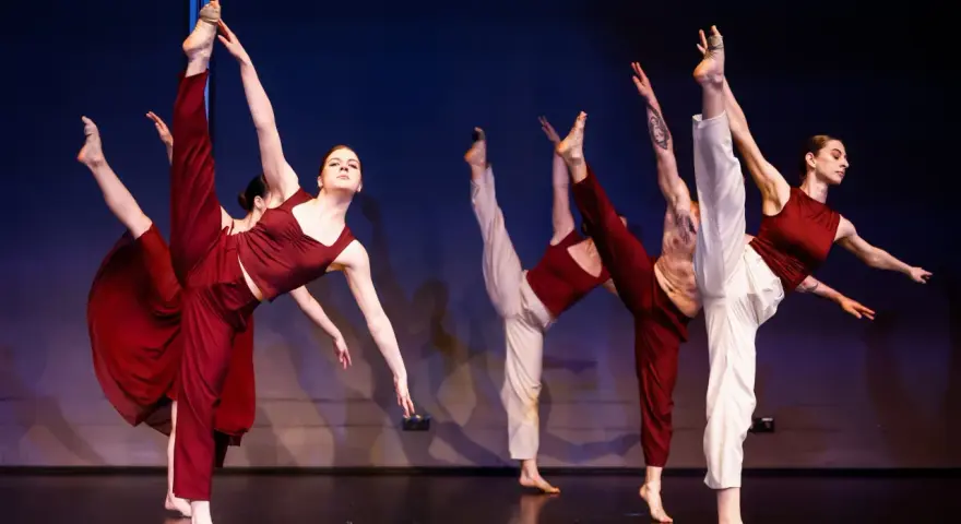 Tancerze wykonują dynamiczny jazz dance, unosząc nogi w powietrze.