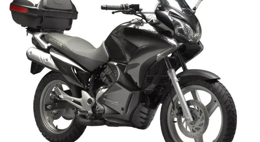 Czarny motocykl Honda Varadero 125 z kufrem, gotowy na podróż.