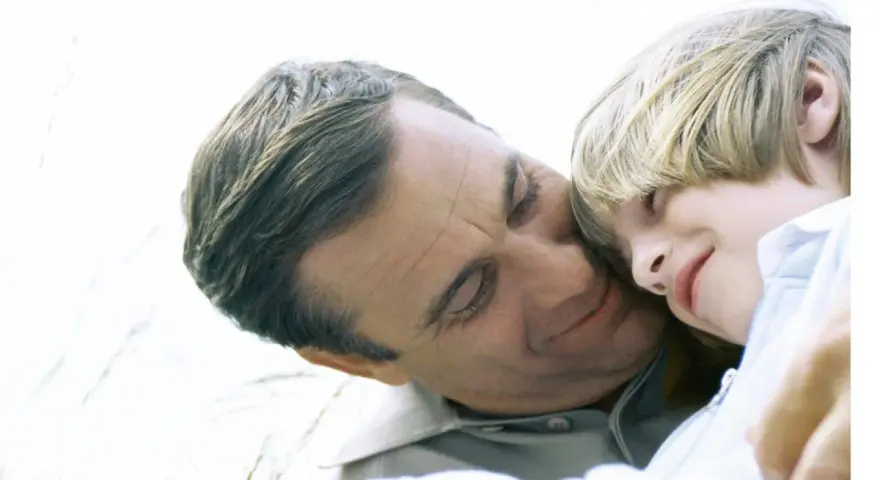 Vater und Kind kuscheln. Auch bei getrennt lebenden Eltern ist die Haftpflichtversicherung wichtig für den Nachwuchs.