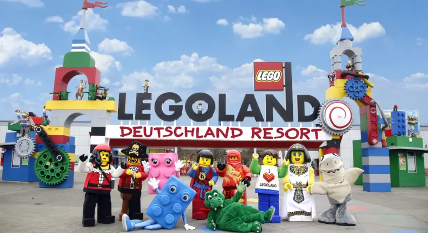 Bunte Lego-Figuren vor dem Legoland Deutschland Resort. Die Szene könnte an einem Wochentag aufgenommen worden sein, um die Legoland Besucherzahlen zu studieren.