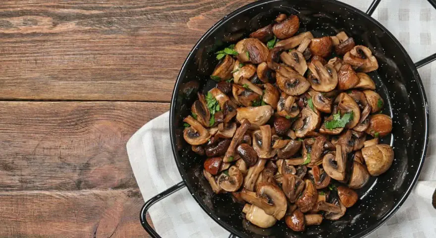 Funghi in padella, dorati e profumati, pronti per essere gustati.