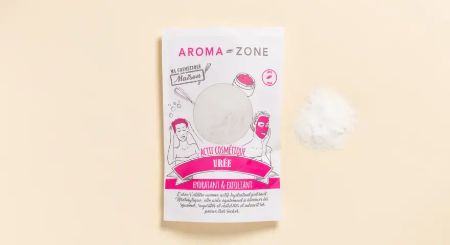 Un sachet d'actif cosmétique "Urée" d'Aroma-Zone, idéal pour hydrater et exfolier, avec une poudre blanche à côté.