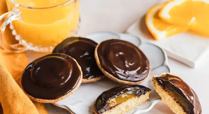 Schokoladige Jaffa Cakes mit Orangenmarmelade, perfekt für ein Jaffa Cake Rezept. Dazu ein Glas Orangensaft.