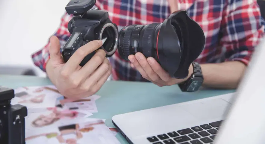 Fotograf przygotowuje sprzęt. Zastanawia się, czy robienie zdjęć z ukrycia jest karalne, przeglądając wydrukowane fotografie.