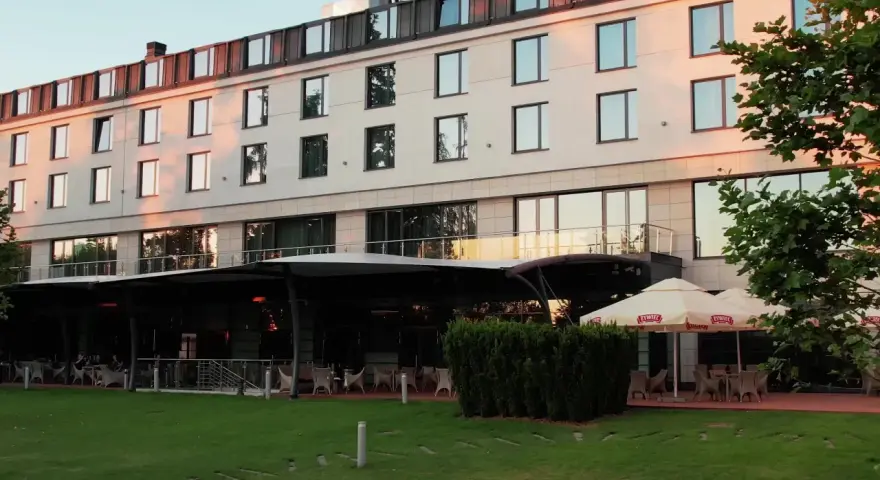 Nowoczesny hotel z tarasem i ogródkiem, gdzie można usiąść. Czy to jeden z hoteli Hilton w Warszawie?