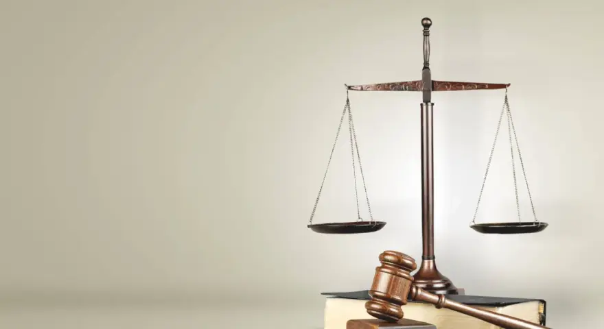 Waga sprawiedliwości i młotek sędziowski na księgach prawnych. Symbolizuje to prawo i porządek, jak w Svea Ekonomi Cyprus Limited.