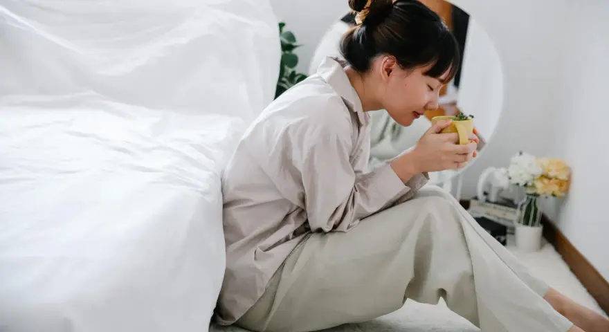 Mujer con taza de té, buscando remedios caseros para dormir de un tirón.
