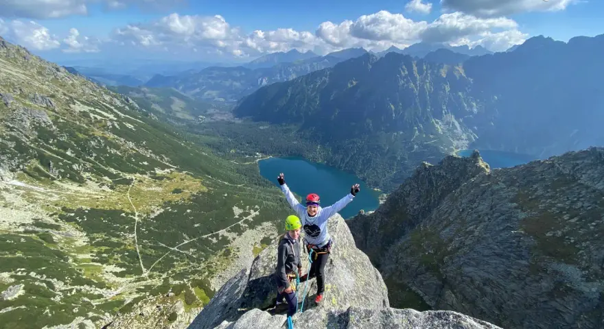 Dwóch wspinaczy na szczycie Mnich z widokiem na Tatry i Morskie Oko.