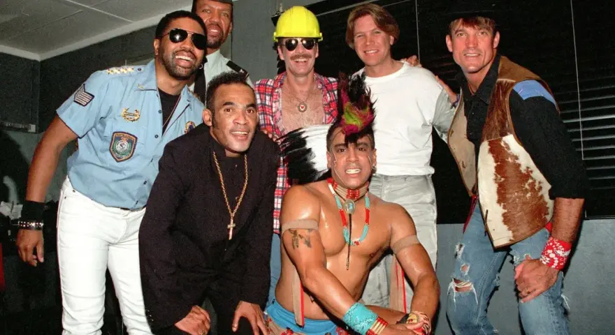 Groupe d'hommes costumés, certains rappelant des figures du disco. Qui a inventé le disco ? Difficile à dire avec ce joyeux groupe !