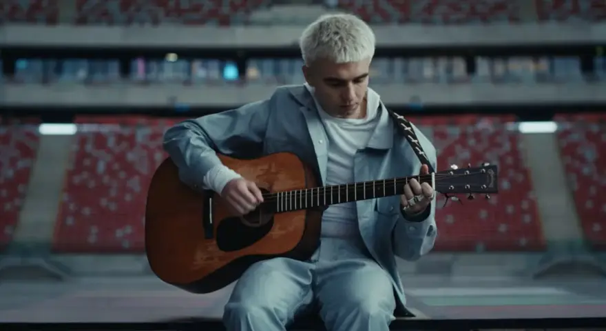 Mata gra na gitarze w pustym stadionie, zapowiadając swój nowy album.