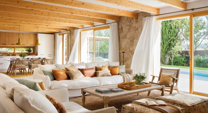 Salones de casas modernas con techos de madera, sofás blancos y vistas a una piscina.