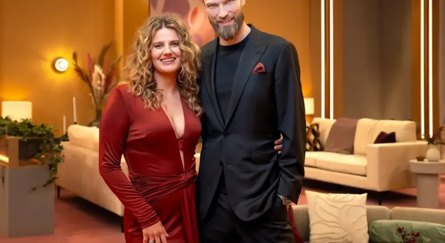 Para Netflix co obejrzeć? Para w eleganckich strojach pozuje na tle przytulnego wnętrza.