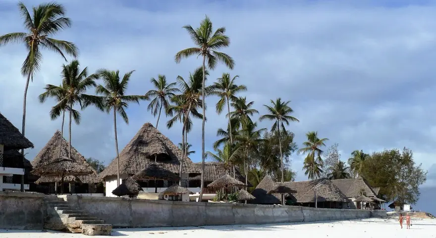 Rajskie plaże Zanzibaru, palmy i domki z krytymi strzechą dachami. Przed wyjazdem warto pomyśleć o zanzibar szczepienia.