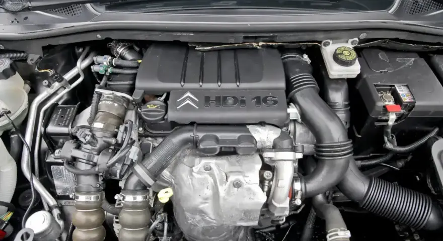 Silnik 1.6 e-HDi z turbosprężarką i elementami układu dolotowego. Widoczna pokrywa silnika z logo Citroen.