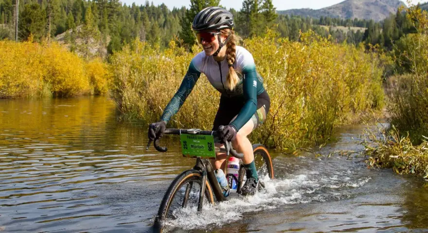 Moriah Wilson splashes through a river on her bike, a challenging part of the race. Kaitlin Armstrong might have faced similar obstacles.