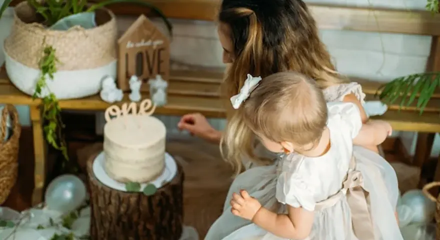 Mama z córką przy torcie na roczek. Piękny tort i dekoracje, idealne na prezent, co kladzie sie dziecku do wyboru na roczek.