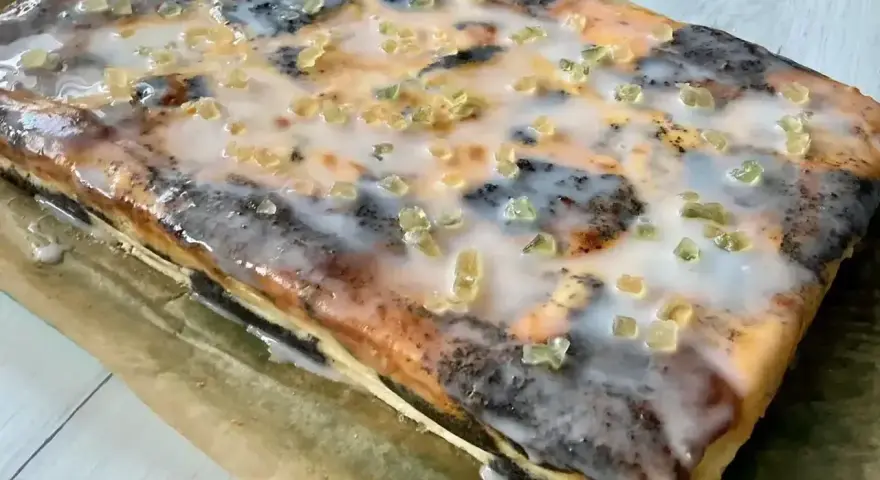 Pyszny seromakowiec z gotowej masy makowej i sera z wiaderka na kruchym spodzie, polany lukrem i posypany kandyzowanymi skórkami.