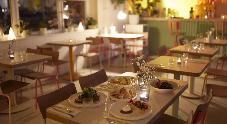 Gemütliche Tische mit Essen und Kerzenlicht im Blumental Berlin.