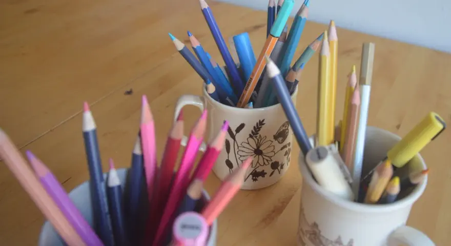 Färgglada pennor i muggar, redo för nya rit tips. En härlig samling för kreativitet.