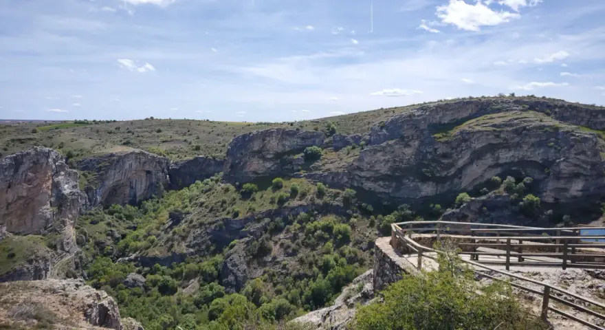 Impresionante vista del **barranco del Río Dulce**, con sus paredes rocosas, vegetación exuberante y un mirador de madera.