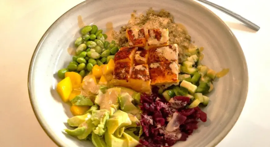 En färgstark bowl med lax, quinoa, edamamebönor, mango, avokado och rödbetor. Perfekt för en snabb middag.