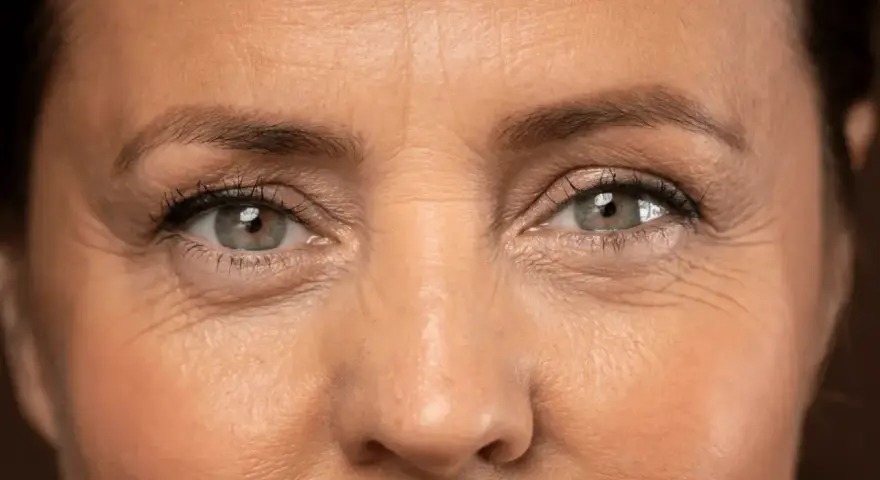 Primer plano de unos ojos con arrugas en los ojos a los 40, reflejando una vida de sonrisas y experiencias.