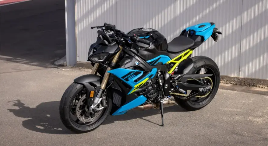 Potężny motocykl BMW S1000R w jaskrawych kolorach niebieskim i żółtym, gotowy do jazdy po torze.