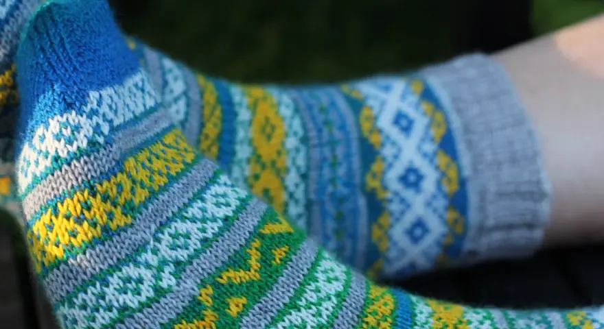 Två par stickade sockor med färgglatt sticka mönster med två färger i blått, gult, grönt och vitt.