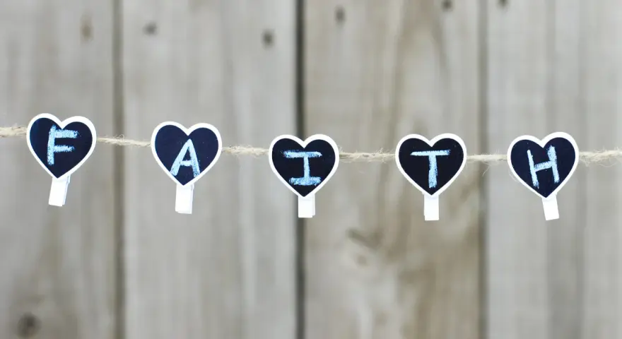 Five heart-shaped clothespins spell "FAITH" on a string, a reminder for prayers for children.